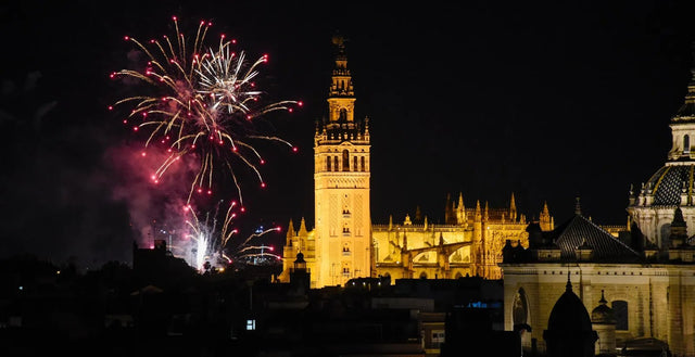 Fuegos artificiales en el cielo de Sevilla junto a la Giralda iluminada